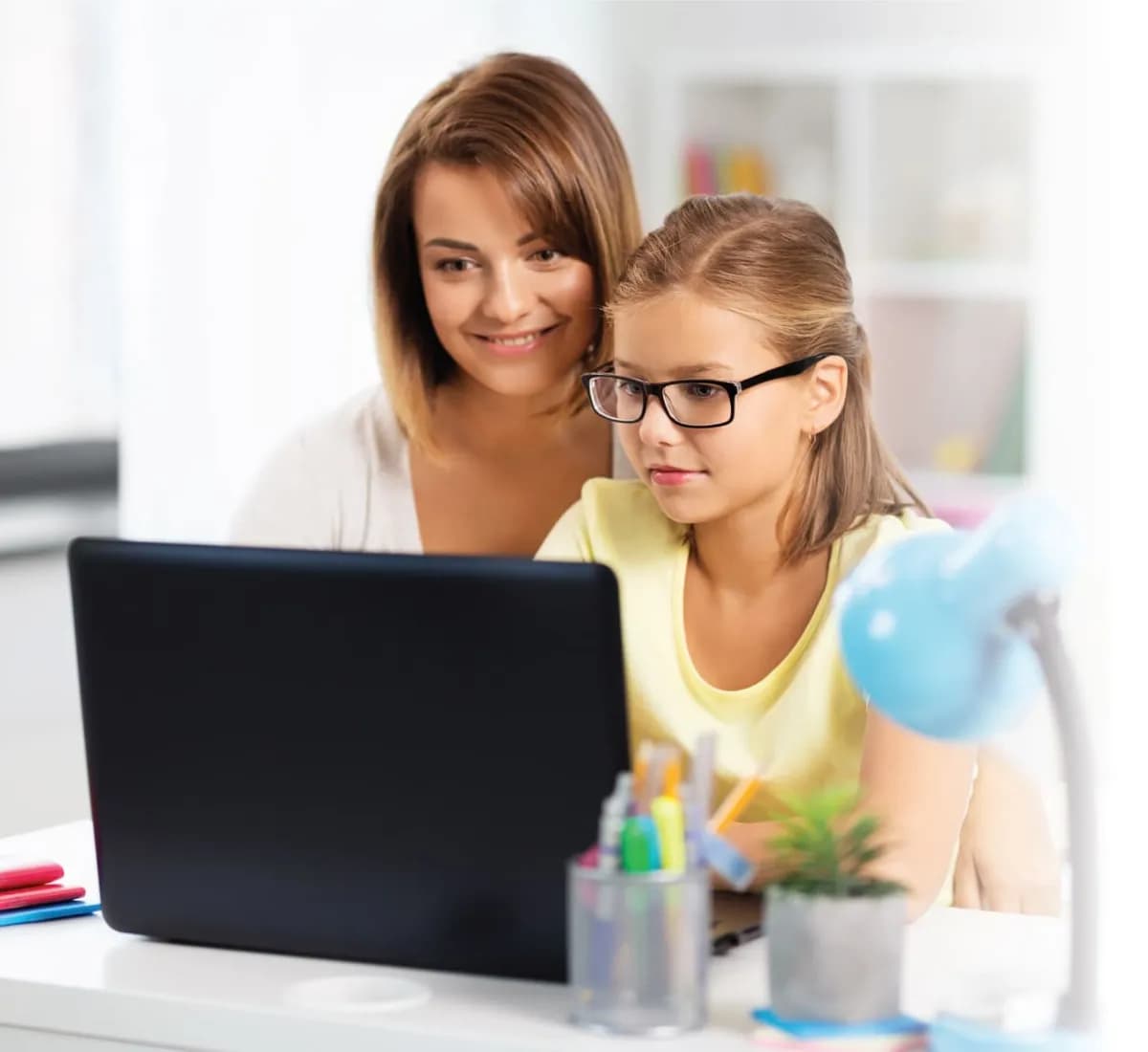 Parent and daughter learning together on a laptop at home
