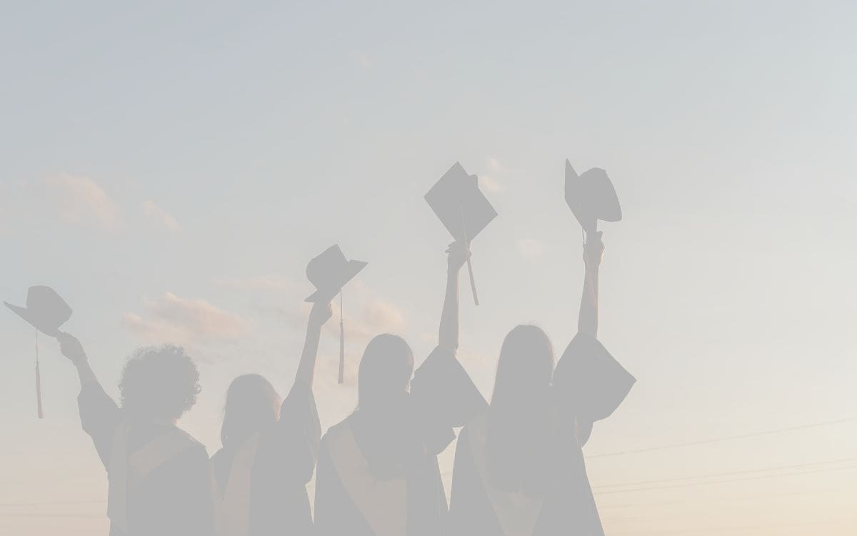 Grayed out image of graduates holding up their graduation caps in celebration. Ohdela Testimonial. A Game-Changer for Our Family.