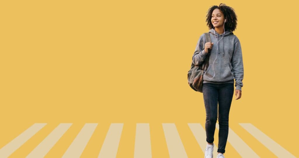 Student walking forward on yellow background